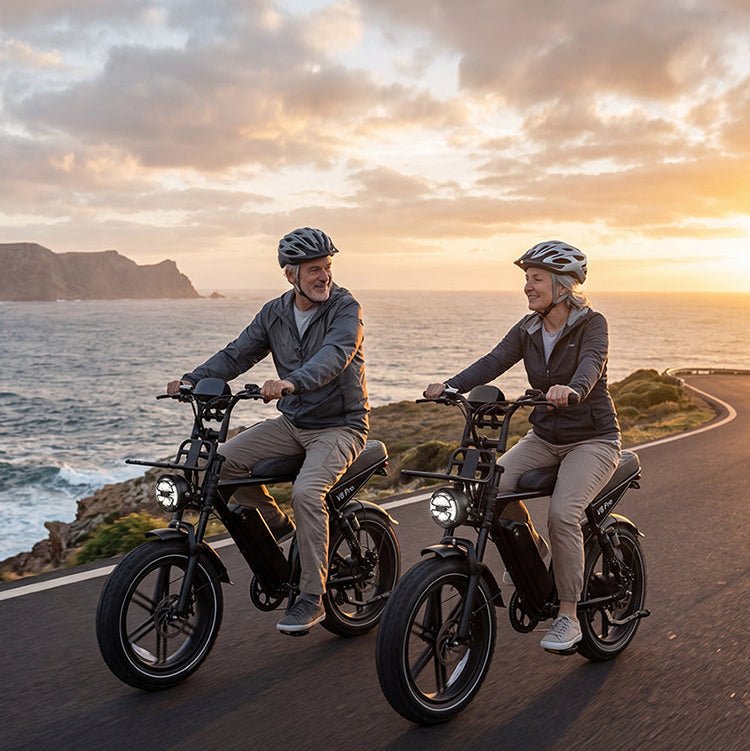 Casal em bicicletas elétricas OUXI V8 Pro em estrada costeira ao pôr do sol.